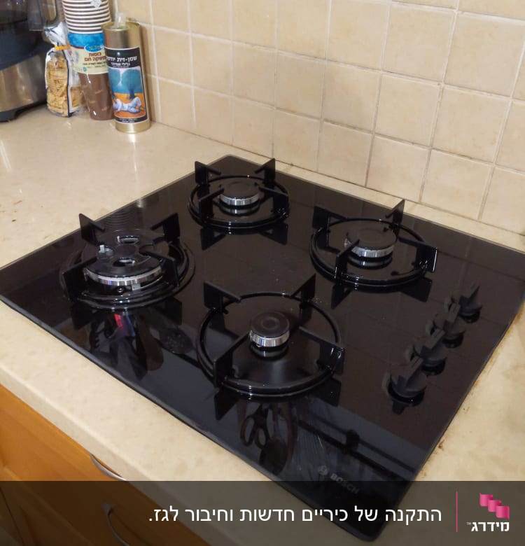 כיריים גז שחורות עם ארבעה מבערים וכפתורים